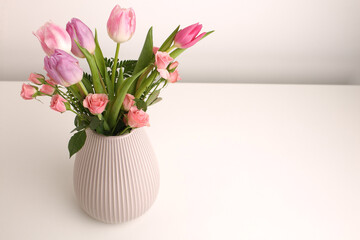 White spring tulips in a vase on a white table. Mock up for displaying works