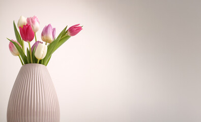 White spring tulips in a vase on a white table. Mock up for displaying works