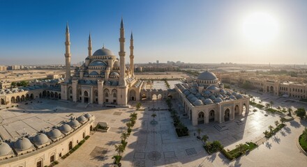 Fototapeta premium Aerial view of a grand mosque with minarets against a clear sky at sunrise