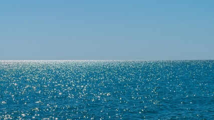 Lake Michigan on a clear day with rippled sparkling surface below clear blue sky