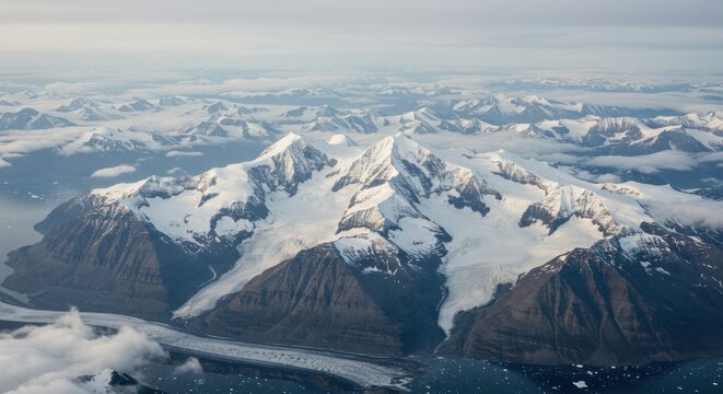 Aerial view of majestic snow-capped mountains with glaciers and cloudy sky