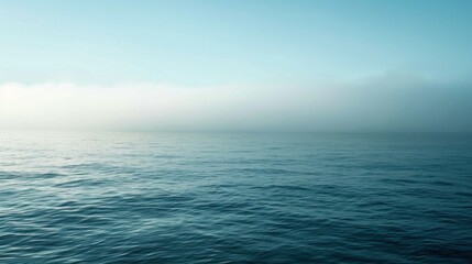 Obraz premium An expansive ocean landscape covered with a soft layer of fog