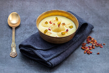 Rasmalai is a soft, spongy Indian dessert made of chhena (paneer) dumplings soaked in sweet, flavored milk, garnished with saffron, cardamom, and nuts.
