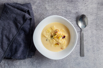 Rabdi is a rich, creamy Indian dessert made by slow-cooking milk until thick, then sweetened with sugar, flavored with cardamom, and garnished with nuts.