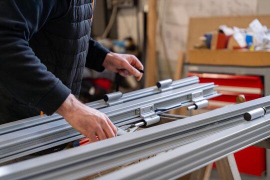 Fototapeta Zoom sur la fabrication de menuiserie en aluminium dans un atelier, mettant en avant les techniques précises et les matériaux de haute qualité utilisés.