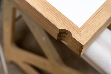 Focus sur la fabrication de meubles en bois dans un atelier de menuiserie, créés sur mesure pour un hôtel haut de gamme, mettant en valeur le savoir-faire artisanal et les matériaux de qualité.