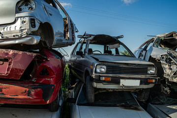 Chaotic pile of damaged and abandoned cars in a junkyard