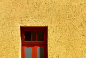 textured yellow wall and red wooden window