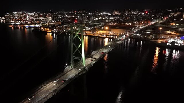 Aerial Cinematic Shot Of The Halifax-Dartmouth Bridge At Night. Traffic Flows Steadily Across, Creating A Beautiful Display Of Urban Lights And Energy, Reflecting The Dynamic Nature Of Nova Scotia.