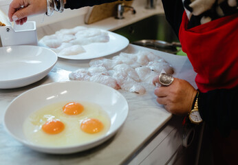Raw fish fillets and eggs prepared for cooking