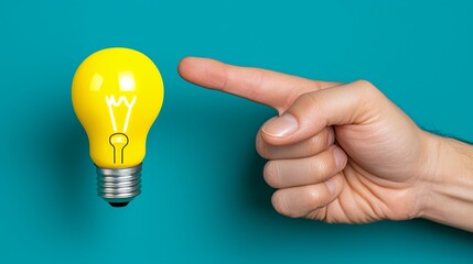 Hand Pointing at Yellow Lightbulb on Teal Background
