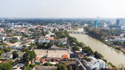 Aerial view of Chiang Mai, Thailand, showcasing urban landscape with Ping River flowing through city center with pollution