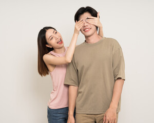 Fototapeta premium Close the. eyes guess what Happy asian couple attractive in various action gesture standing on isolated white background. Cheerful Smiling young man and woman hide and seek