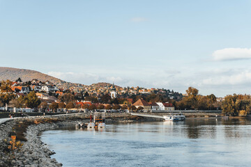 Obraz premium small town village in autumn look with trees by the danube river waters in hungary