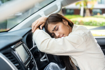 Young asian businesswoman driver was drowsy. She yawned and was about to fall asleep in car doze...