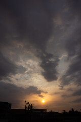 Sunset in the city, dramatic sky with clouds and sun.
