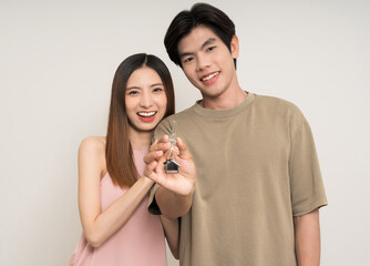 Happy family asian couple attractive in various action gesture holding house key on isolated white background. Cheerful Smiling young man and woman buy new home showing key of the house