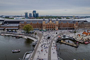 Beautiful aerial view of  Amsterdam Centraal Train Station and its historic hub with canals, bikes, cafes. Netherlands