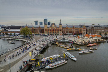 Beautiful aerial view of  Amsterdam Centraal Train Station and its historic hub with canals, bikes, cafes. Netherlands