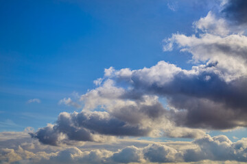 Gray clouds in the sky in a single row, gray clouds in the blue sky signaling a weather change,...