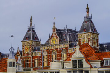 Fototapeta premium Beautiful aerial view of Amsterdam Centraal Train Station and its historic hub with canals, bikes, cafes. Netherlands