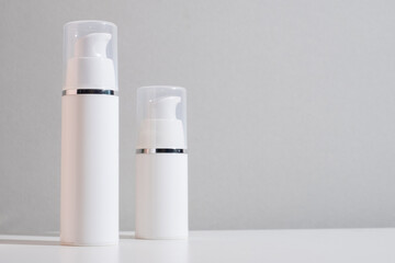 White plastic bottles for cream, shampoo, toiletries, spa. Bottle with a dispenser for cosmetic products. Skin care and beauty concept. Mockup style, copy space