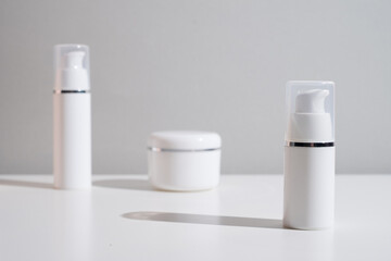 White plastic bottles for cream, shampoo, toiletries, spa. Bottle with a dispenser for cosmetic products. Skin care and beauty concept. Mockup style, copy space