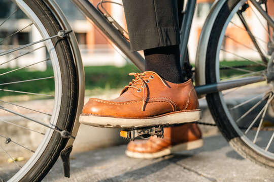 Close up foot. businessman riding bike in city. sustainable save energy lifestyle. Commute and carbon neutral transportation. Man cycling bike to working office in urban city