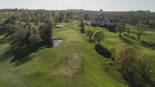Aerial View Of A Golf Course Featuring Players Competing On The Green And Groundskeepers Ensuring The Quality Of The Field. The Scene Showcases The Beauty Of Nature And The Importance Of Turf Care.