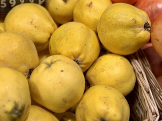 Ripe, fresh, yellow quinces in baskets on sale at the market in the grocery store, fruits and vegetables. Close-up