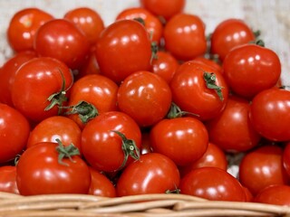 Fresh red tomatoes in container baskets, offered for sale at the supermarket's vegetable stand, showcase organic, vegetarian and healthy food. Close-up