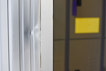 close-up view of a metallic surface with vertical grooves. There is a noticeable dent or...