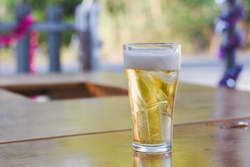 A glass of beer with ice on the table