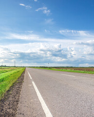 Long, empty road with a few trees in the background