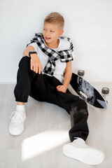 a teenage boy with a skateboard, a child boy on a white background, a space and a place for text, a child playing sports