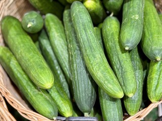 A lot of green cucumbers in a market counter for sale on sale in vegetable stand display at supermarket show organic food, vegetarian food, healthy food. Close-up