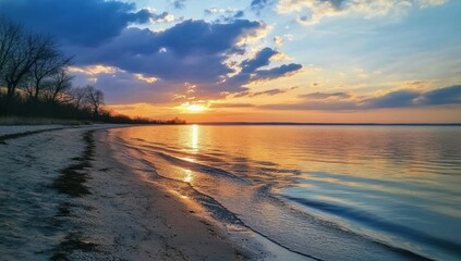 Obraz premium Serene sunset over calm ocean beach.