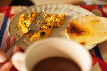 Traditional breakfast with scrambled eggs, arepa and hot chocolate. Ideal for concepts related to Latin American cuisine, homemade meals and breakfast traditions 