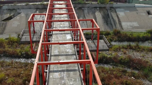 Aerial shot of Taylor Yard Bicycle and Pedestrian Bridge in Los Angeles. California. Modern red bridge and river