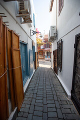 A narrow street between two old white houses.