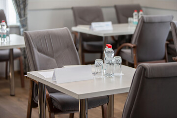 Part of a conference room with empty tables and chairs.