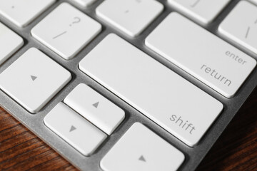 Technical support concept. Modern keyboard on wooden background, closeup