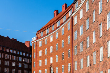 Classic brick buildings with red roofs bask in the sunlight in Helsinki, Finland.