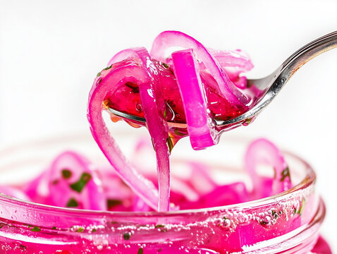 Fork lifting pickled red onions from jar.