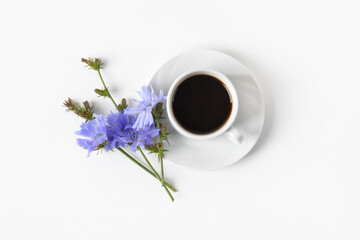 White cup with decaf chicory drink and blue chicory flowers on gray background. Healthy eating