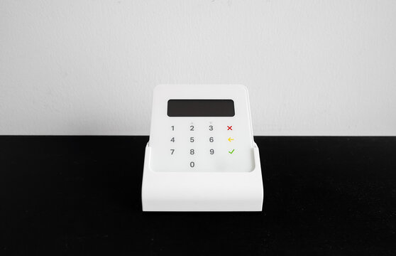 Wireless payment terminal for card or phone transactions on a table.