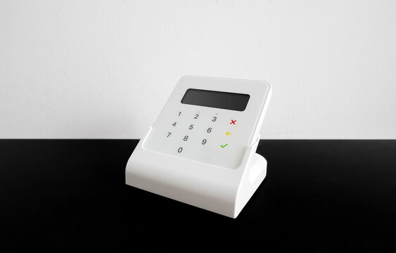 Wireless payment terminal for card or phone transactions on a table.