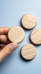 Naklejka premium A hand grasps a wooden checkmark against a blue backdrop, ideal for showcasing business and quality health technology concepts