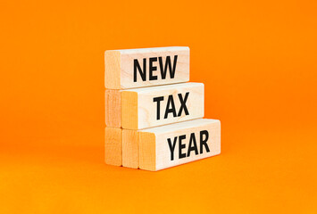 Naklejka premium New tax year symbol. Concept words New tax year on beautiful wooden blocks. Beautiful orange table orange background. Business new tax year concept. Copy space.