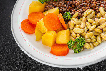 Vegetarian main course vegetables lentils, beans, potatoes, carrots tasty fresh delicious gourmet food background on the table rustic food top view copy space keto and paleo diet vegetarian and vegan 